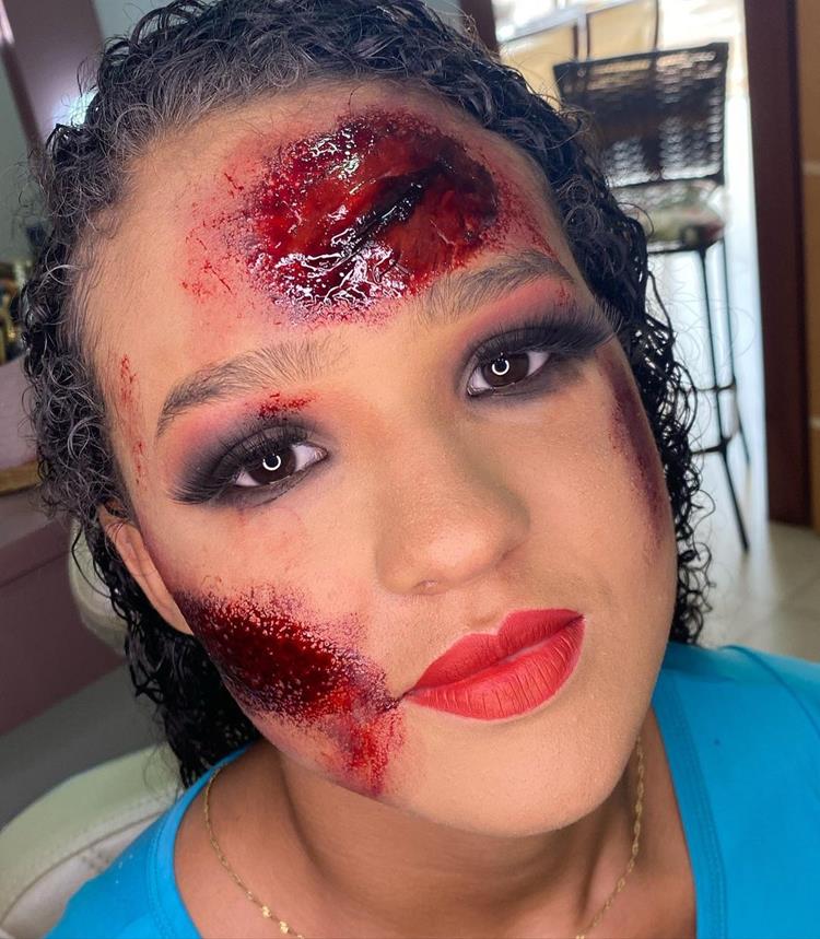 mulher com maquiagem cheia de machucados e sangue falso