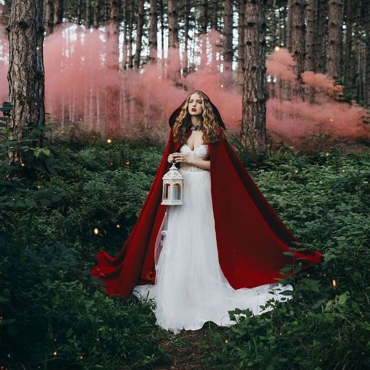 Mulher com fantasia de chapeuzinho vermelho na floresta