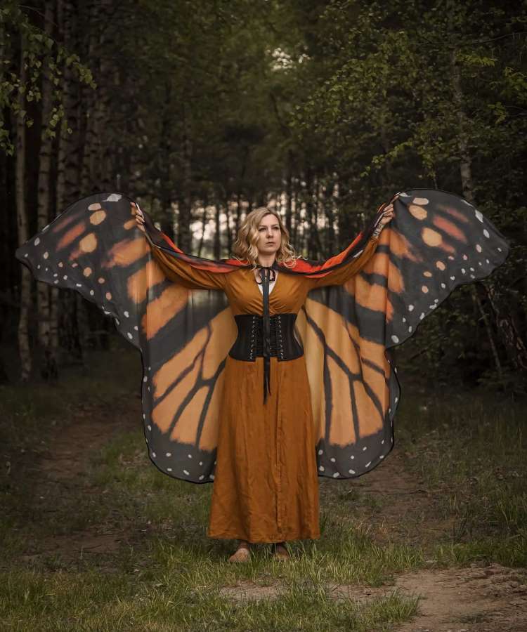 Mulher com capa formato asa de borboleta