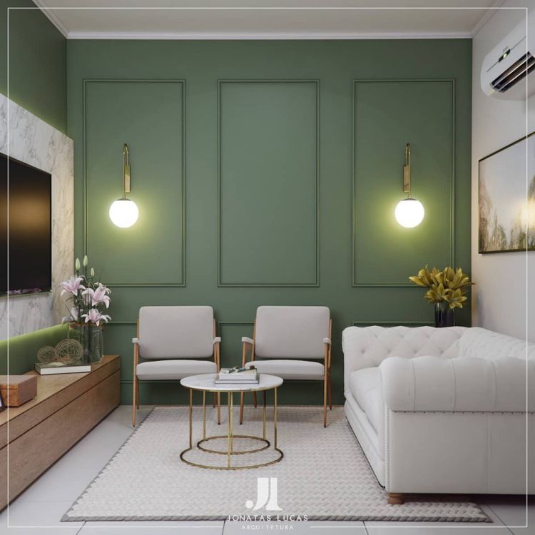 Sala de estar com parede verde musgo, sofá e poltronas brancas, painel de televisão e tapete bege