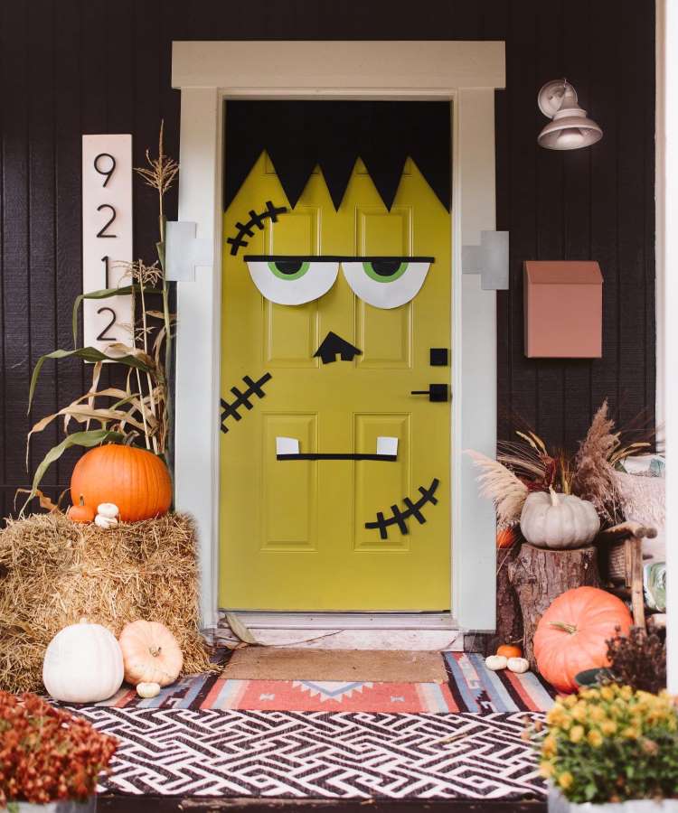 Decoração de porta Halloween com cara montro, feno, abóboras, pé de milho