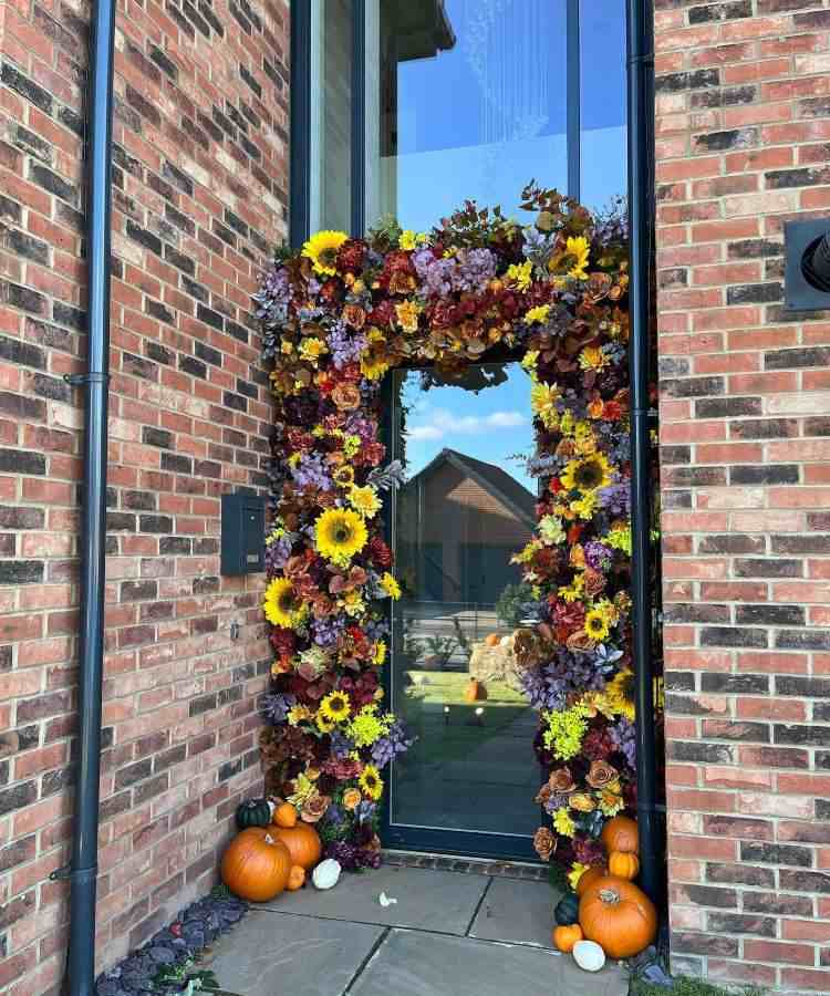 Decoração de porta Halloween com flores e abóboras