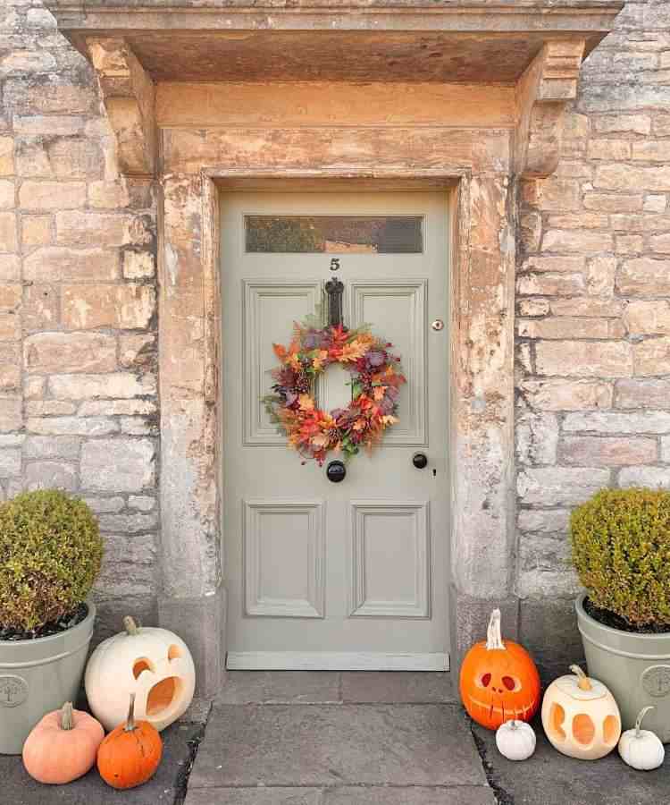 Decoração de porta Halloween com guirlanda e abóboras