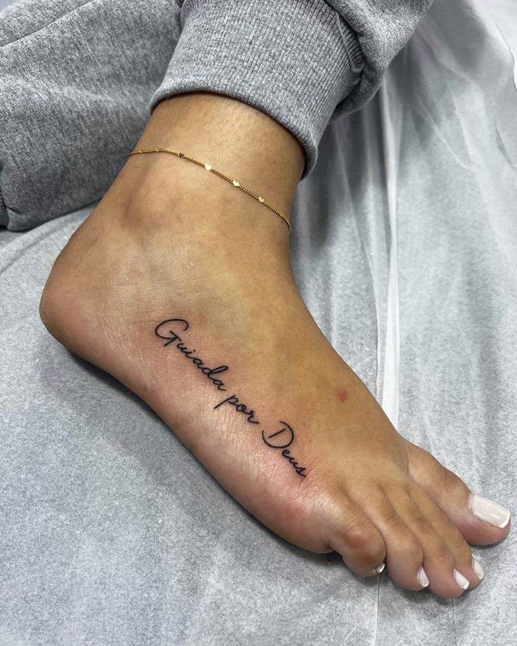 tatuagem escrita  Guiada por Deus no pé