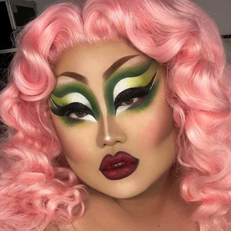 maquiagem drag queen em tons de verde, além de peruca rosa