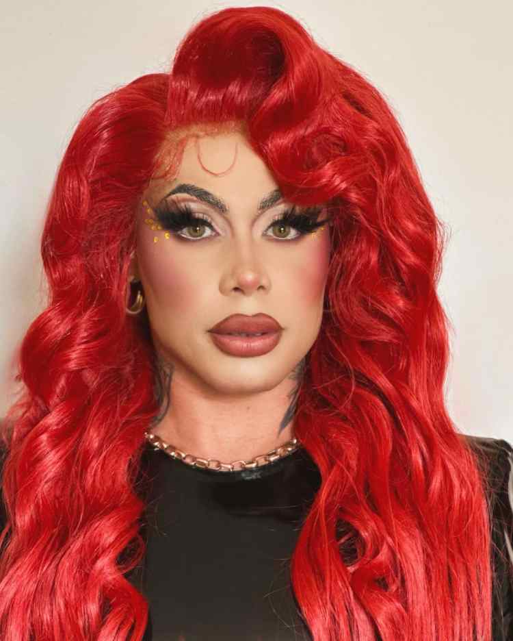 grag queen com peruca vermelha e maquiagem em tons neutros