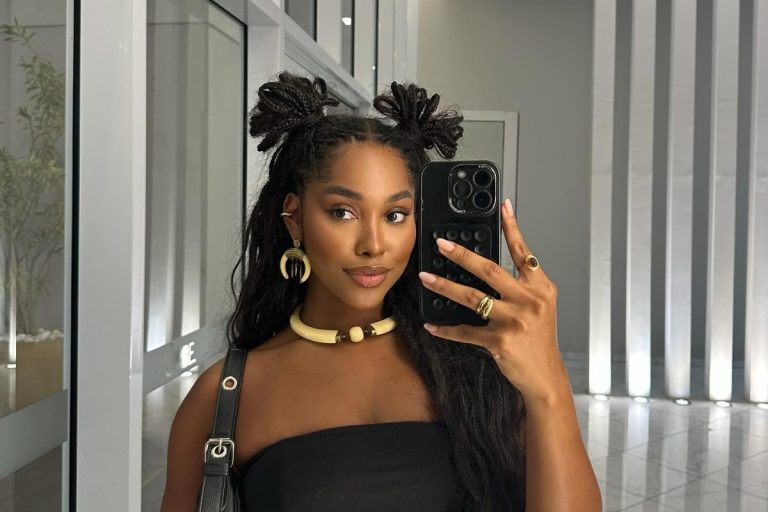 Mulher de pele negra com dois coques no alto do cabelo solto