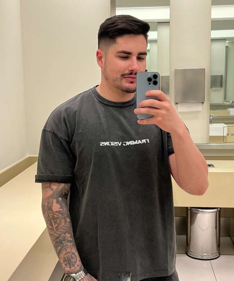Selfie de Lucas Souza, ex de Jojo Todynho, no espelho. Ele usa camisa cor grafite e está em banheiro