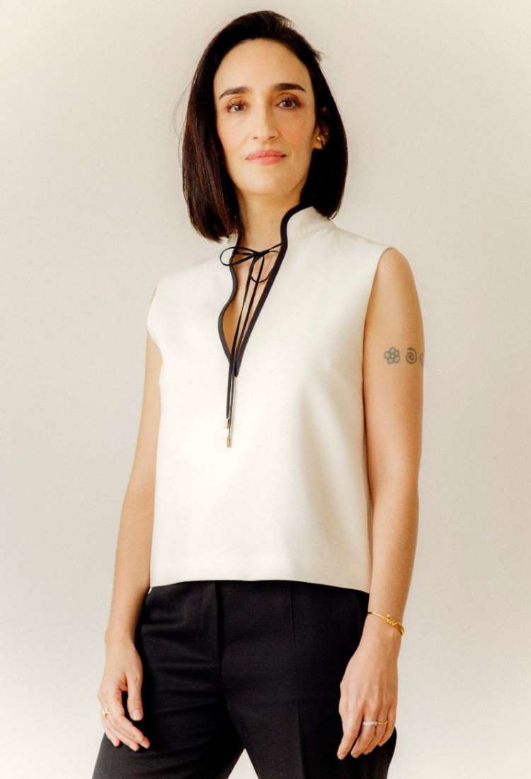 Esposa de Pedro Bial usando blusa branca e calça social preta