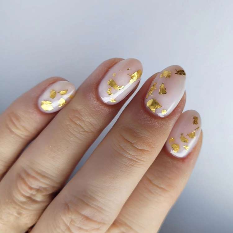 Nail art decorada nas cores: branco e folha de ouro