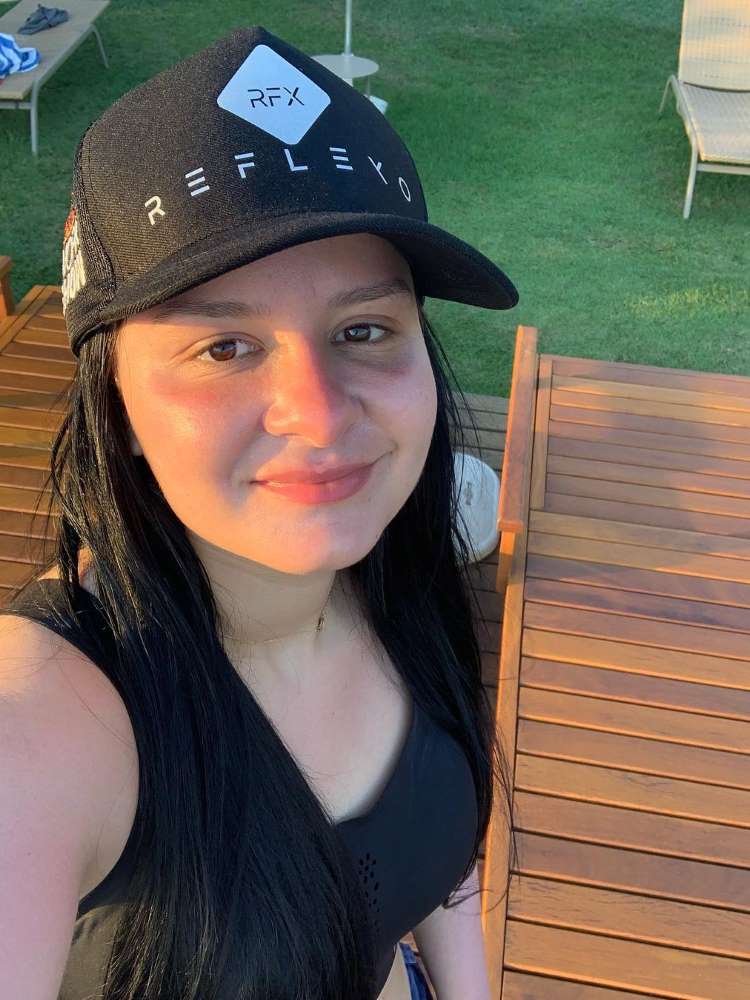 Cantora Maraisa em 2018, antes de fazer rinoplastia, usando boné preto e roupa preta, em área de piscina