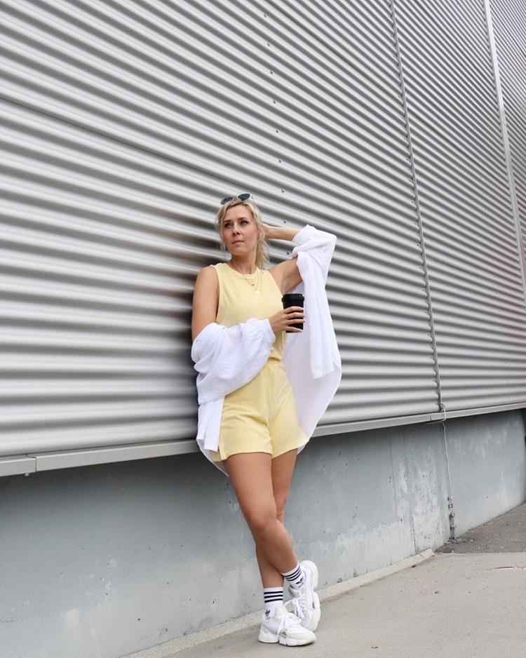 mulher com macaquinho amarelo claro e camisa branca por cima