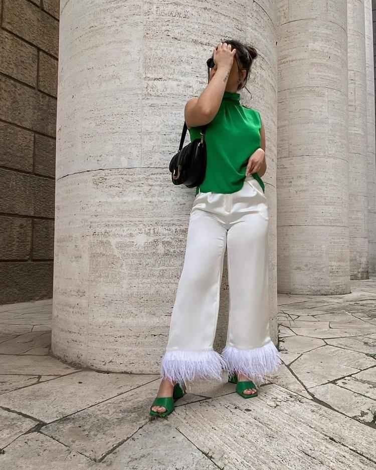 mulher com calça branca e blusa regata verde