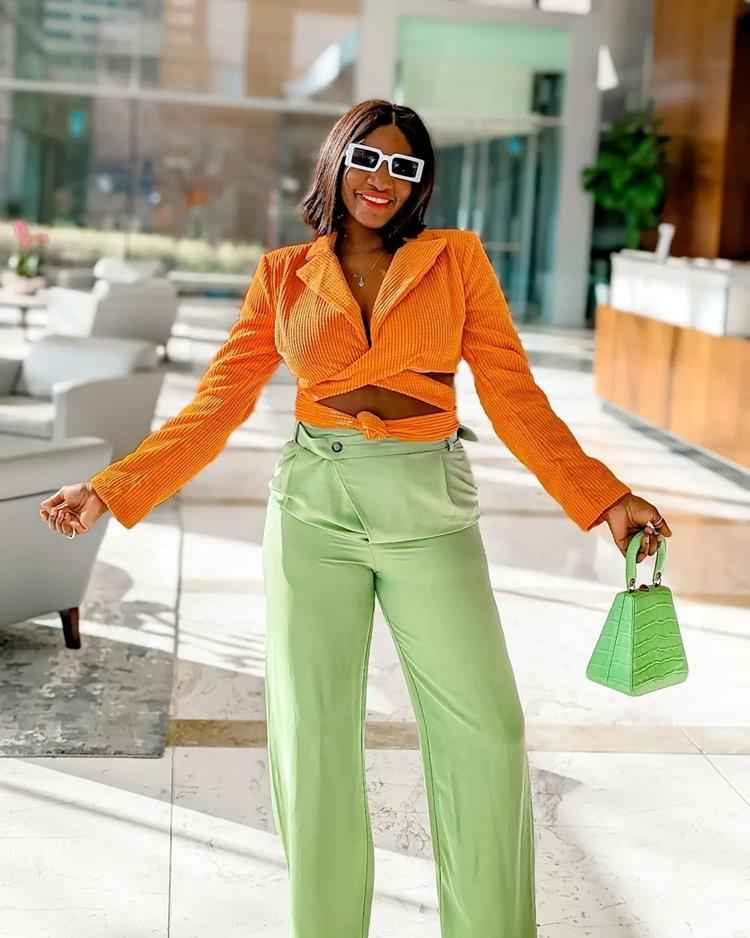 mulher com calça verde e blusa laranja
