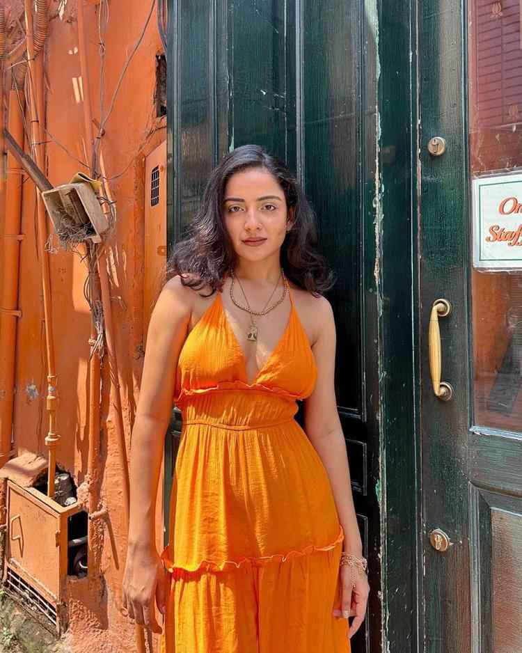 mulher com vestido de alça largo laranja