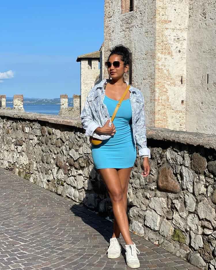 mulher com vestido curto azul e jaqueta jeans