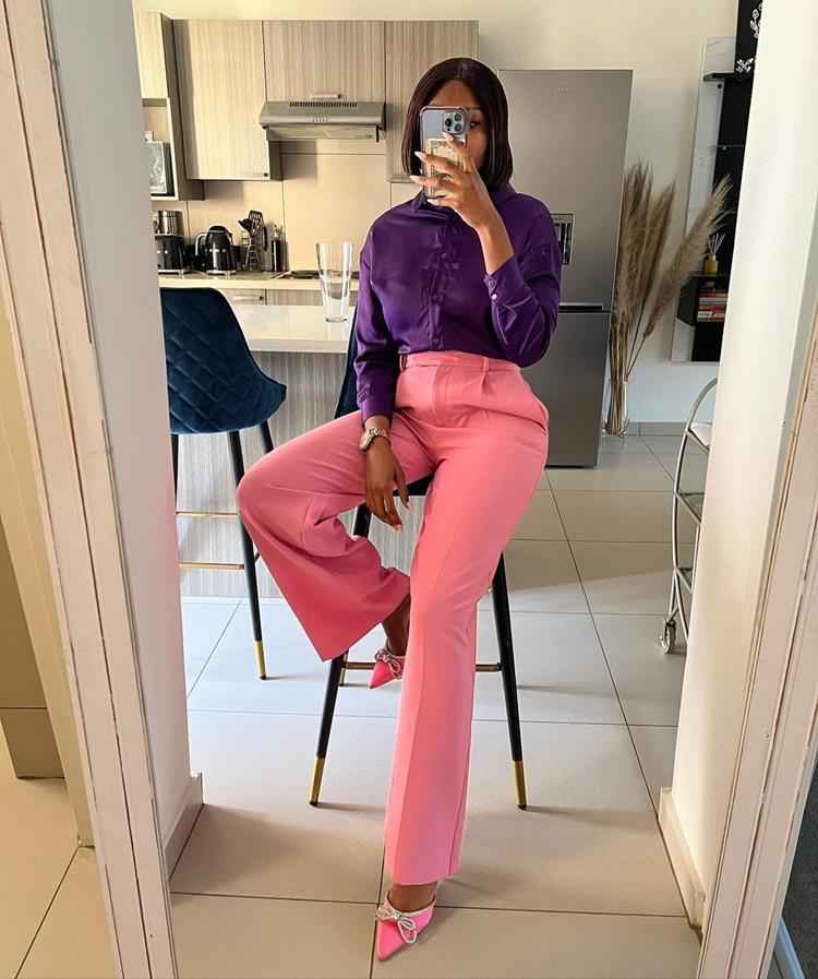 mulher com calça rosa e camisa roxa