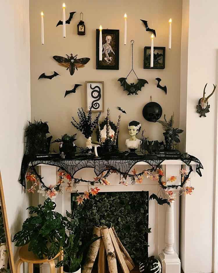 lareira decorada com tema de halloween, elementos escuros como teia, morcego, plantas e caveira