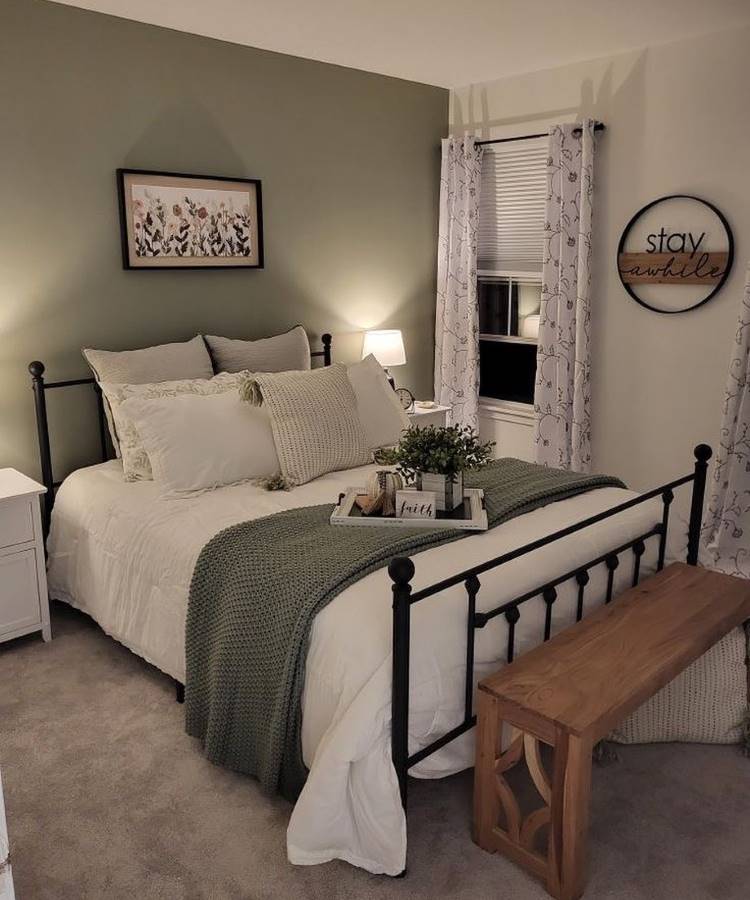 Quarto pequeno para casal decorado com quadro, cortinas florais e roupa de cama verde e branco