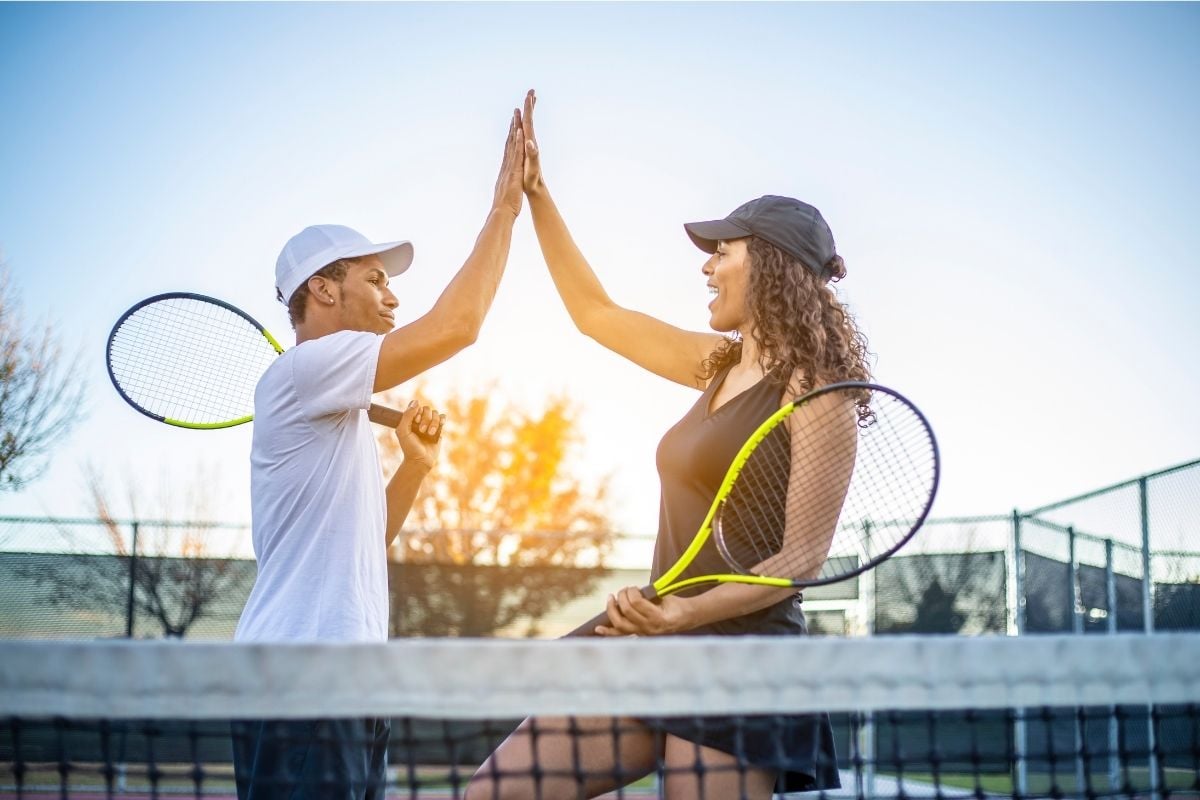 homem e mulher fazendo cumprimento em quadra após usar psicologia no tênis