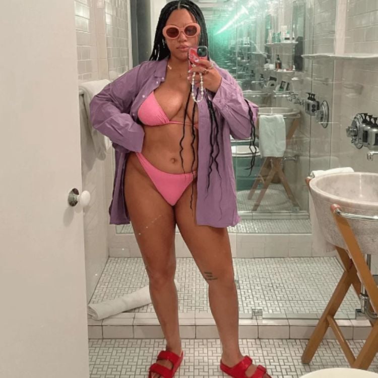 No banheiro, mulher posa com biquíni rosa asa-delta
