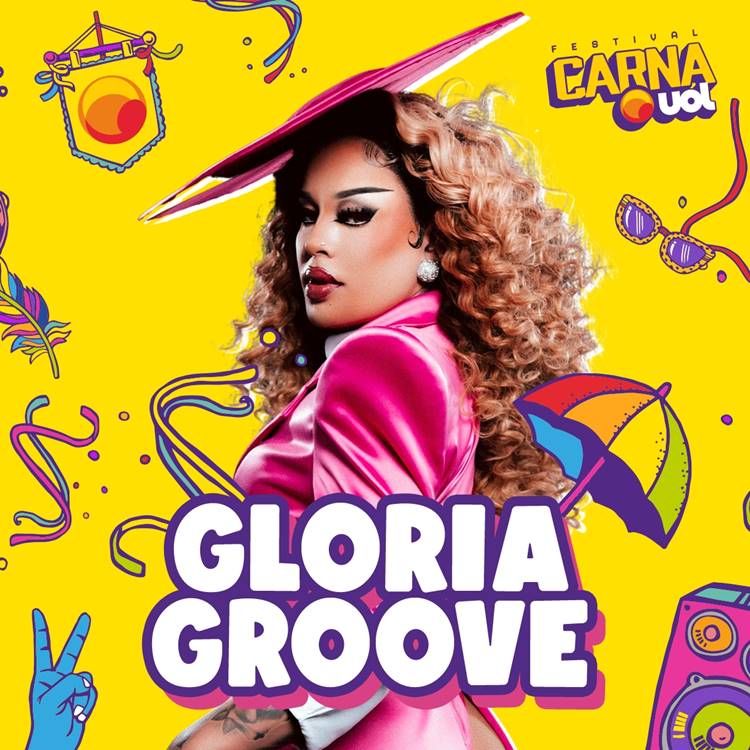 Foto de Gloria Groove com look pink e cabelo louro cacheado, em fundo amarelo com ilustrações coloridas que remetem ao Carnaval, como guarda-chuva de frevo, óculos de sol, pena, etc