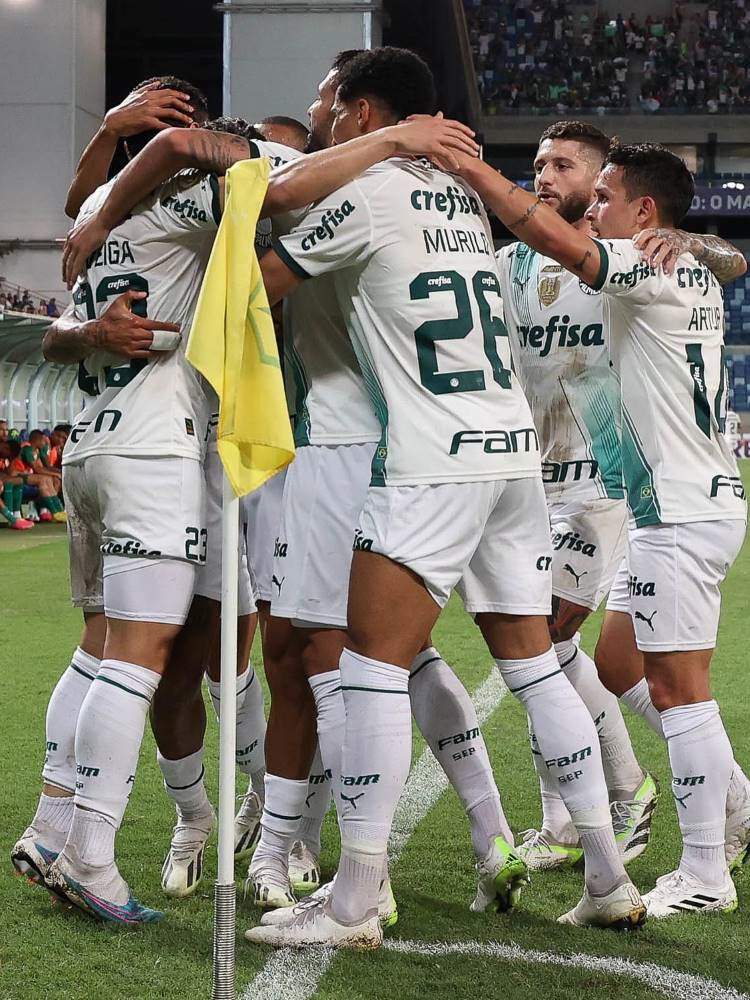 Parte do elenco do Palmeiras se abraçando próximo à bandeirinha. Os jogadores usam o segundo uniforme