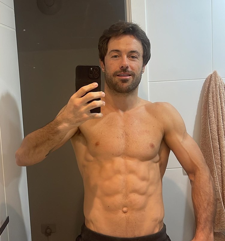 Ator Kayky Brito sem camisa em banheiro com toalha pendurada tirando selfie no espelho
