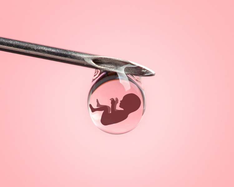 Foto de ponta de agulha com gota segurando desenho digital de bebê, em fundo rosa