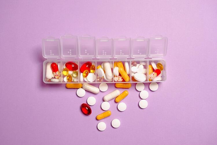 caixa de remédios separada por dias da semana e cheia de pílulas