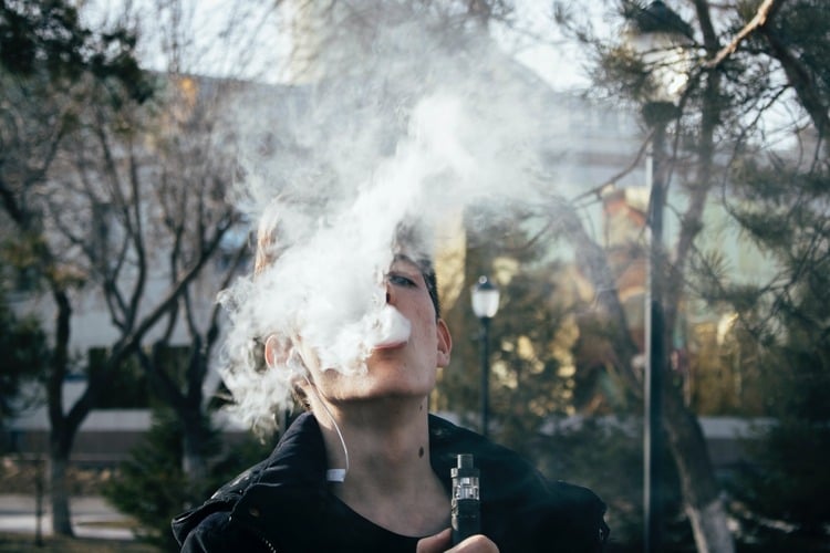 Homem ao ar livre fumando vape