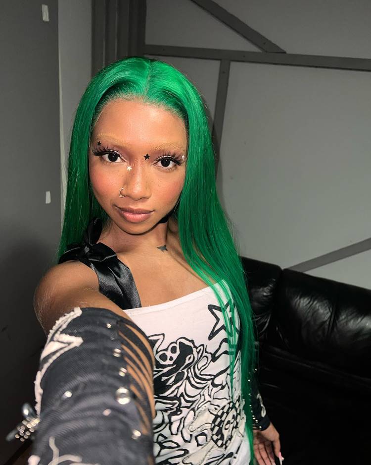 Selfie de Slipmami, com lace verde, sobrancelha apaga com maquiagem, make com estrelas no rosto. Usando roupa branca e preta