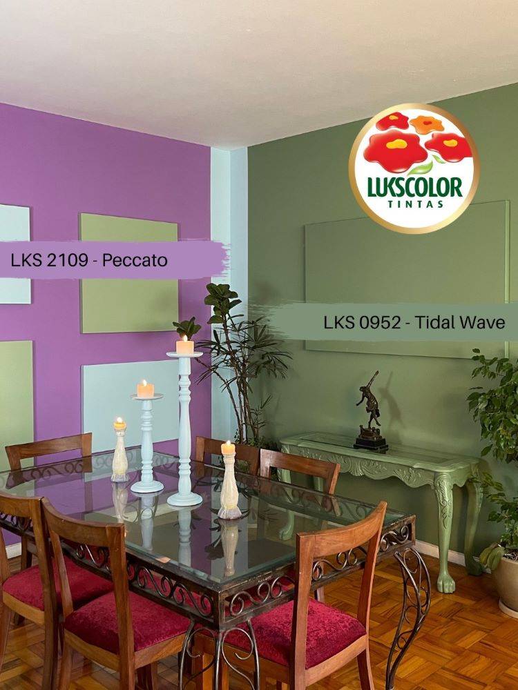 Sala de jantar com mesa de vidro e cadeiras de madeira, cuja parede é roxa e a outra em verde Tidal Wave. 