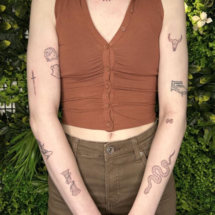 O torço de uma mulher branca de braços tatuados