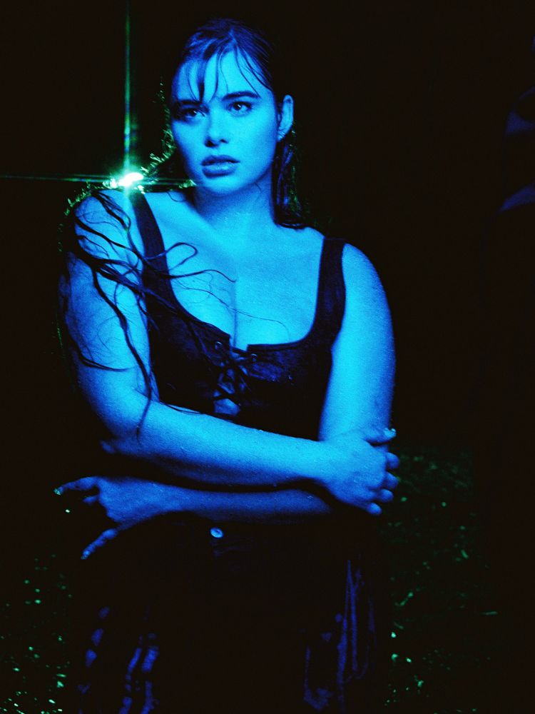 A atriz Barbie Ferreira posa com os braços cruzados, usando um corset preto