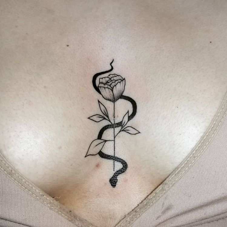 tatuagem de cobra enrolada em uma rosa, entre os seios