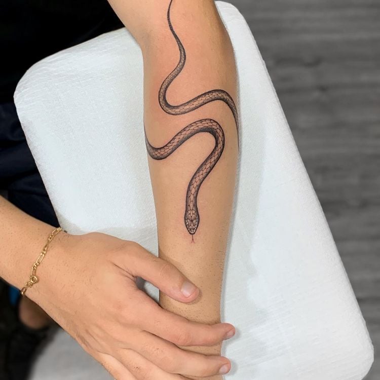 uma tatuagem preta de cobra enrolada pelo braço 