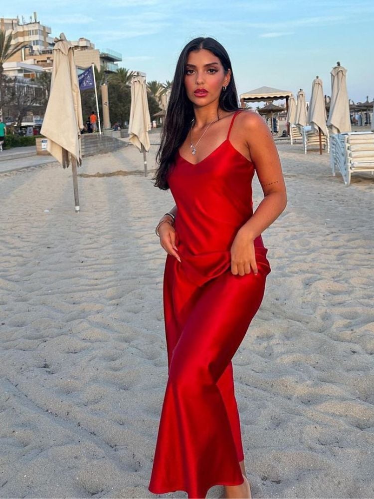 mulher na praia usando slip dress vermelho de cetim