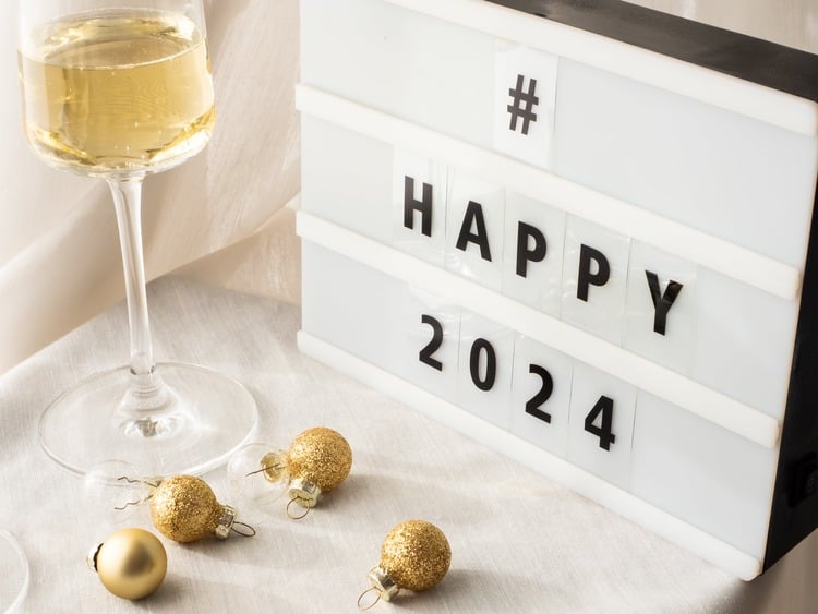 Imagem de um letreiro com o texto 'Happy 204" ao lado de uma taça de champagne