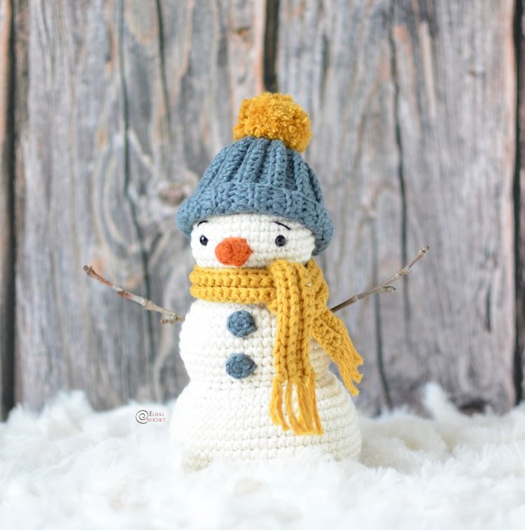 Boneco de neve de crochê com braços de galho, touca e cachecol