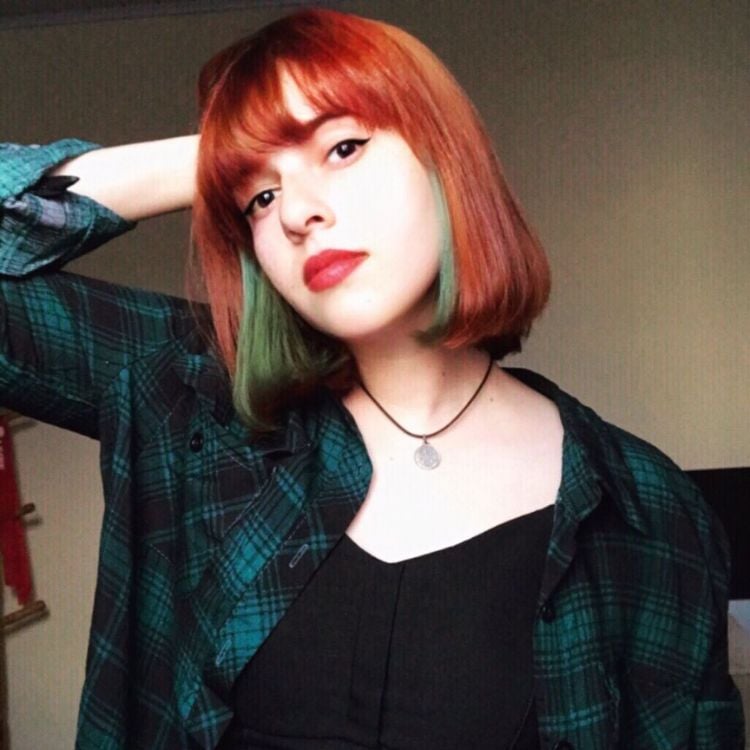 Mulher de cabelo chanel ruivo e verde