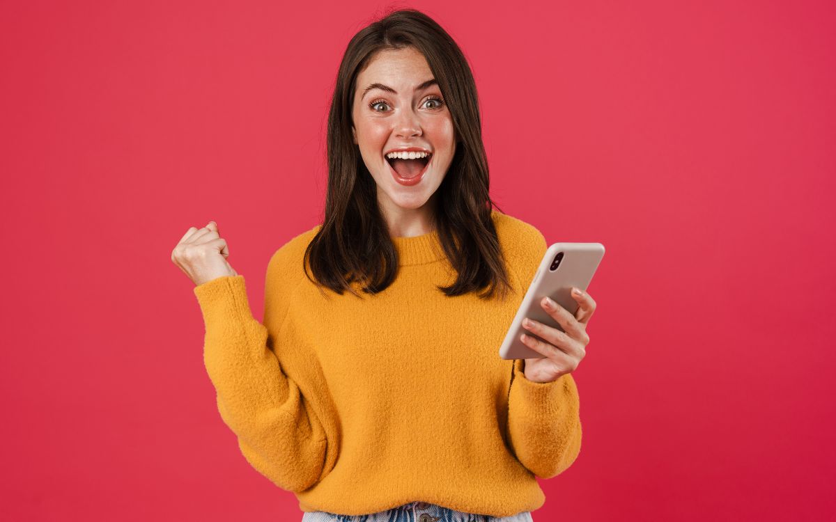 fundo vermelho com mulher segurando celular e jogando em caça-níqueis online