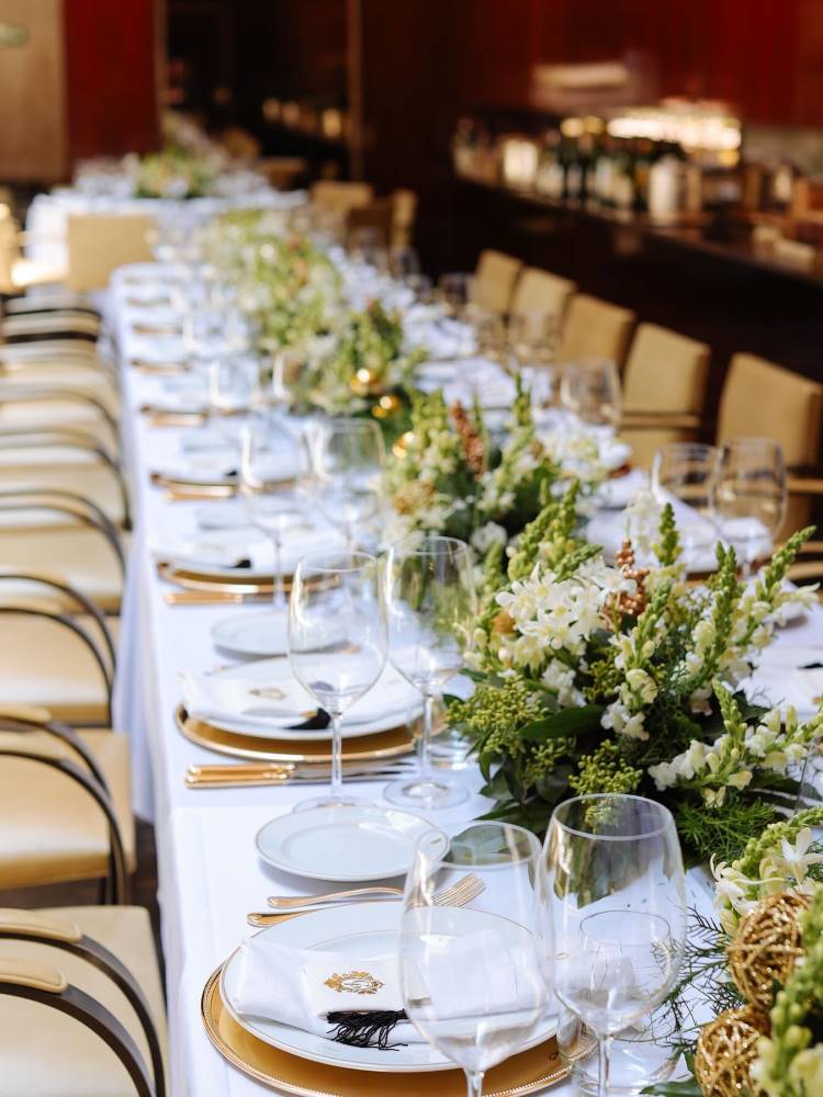 Mesa-posta de almoço luxuosa, com pratos, taças e flores decorando