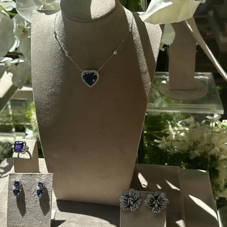Exposição colar de coração, brinco de coração, anel de pedra azul safira quadrada e brinco de flor.