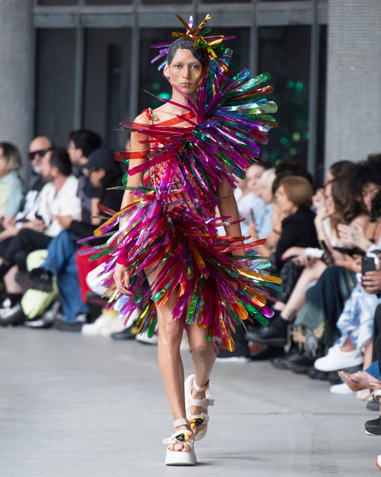 Modelo no desfile do Ponto Firme usando vestido de crochê com detalhe em plástico colorido