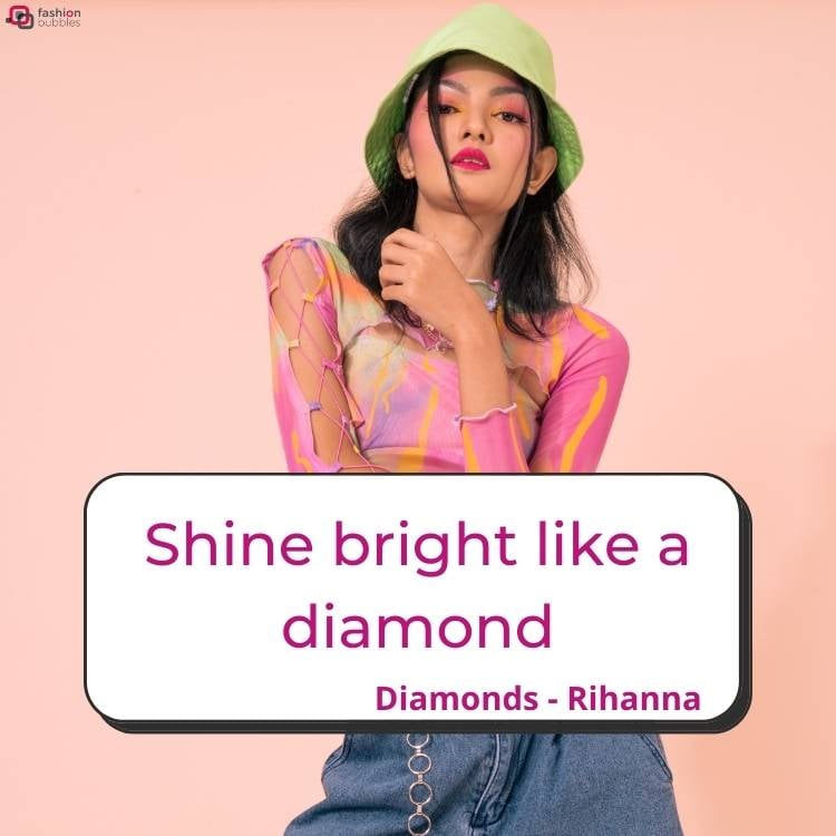 Mulher de pele clara usando bucket verde, blusa rosa e calça jeans em um fundo rosa. Ainda, há o trecho Shine bright like a diamond" e "Diamonds, Rihanna"
