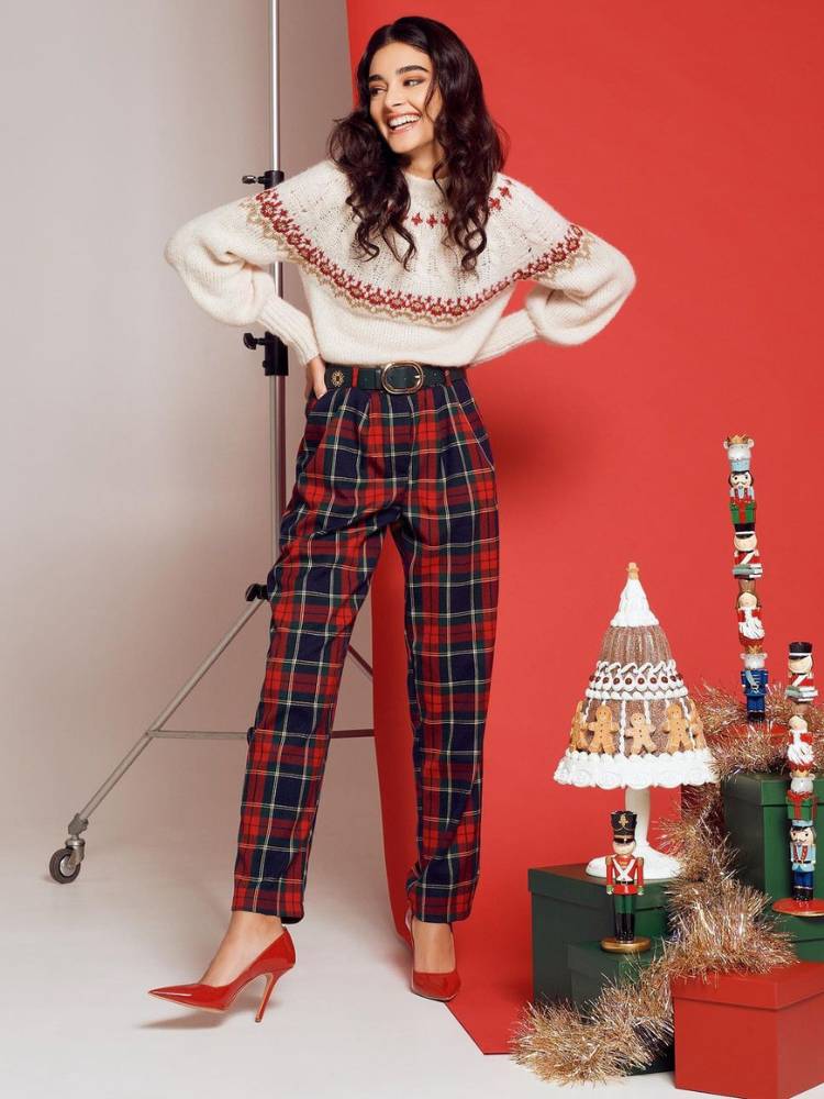 Mulher usa saia xadrez como sugestão de roupa vermelha para Natal