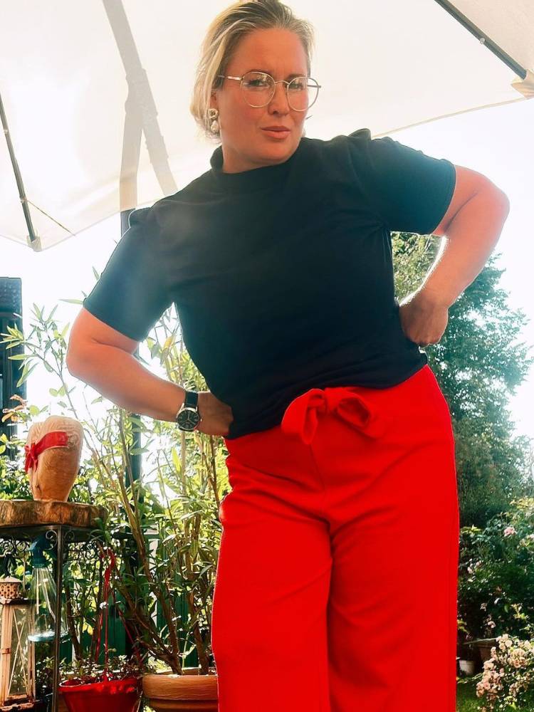 Mulher usa blusa e calça como sugestão de roupa vermelha para Natal