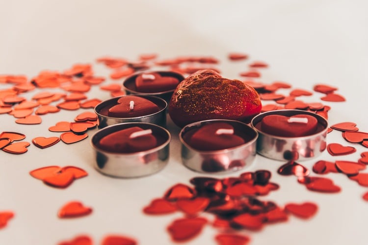 Pequenas velas vermelhas com pétalas de rosas para uma simpatia para o amor