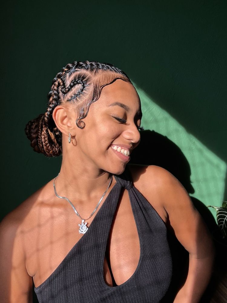 Mulher de pele negra com tranças nagô em coque 